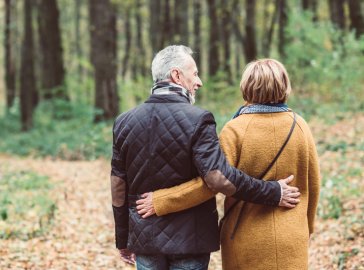 Foto von Paar in Rückansicht beim Spaziergang im Wald 